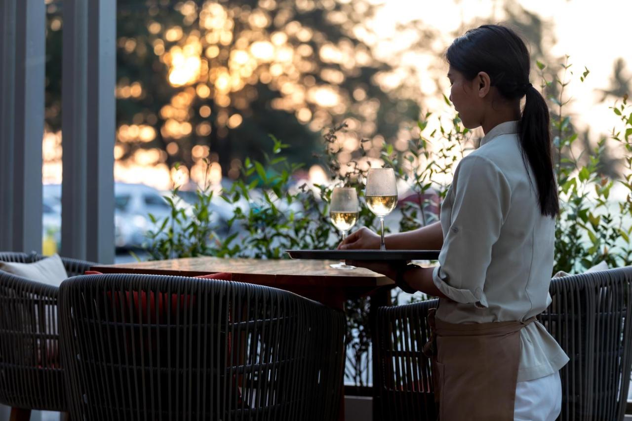 Outrigger Surin Beach Resort - Sha Extra Plus Praia de Surin Exterior foto A waitress clearing a table